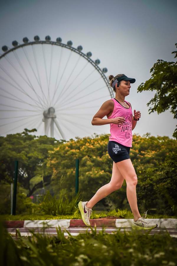 Aluna da Corrida Natural correndo com regata rosa