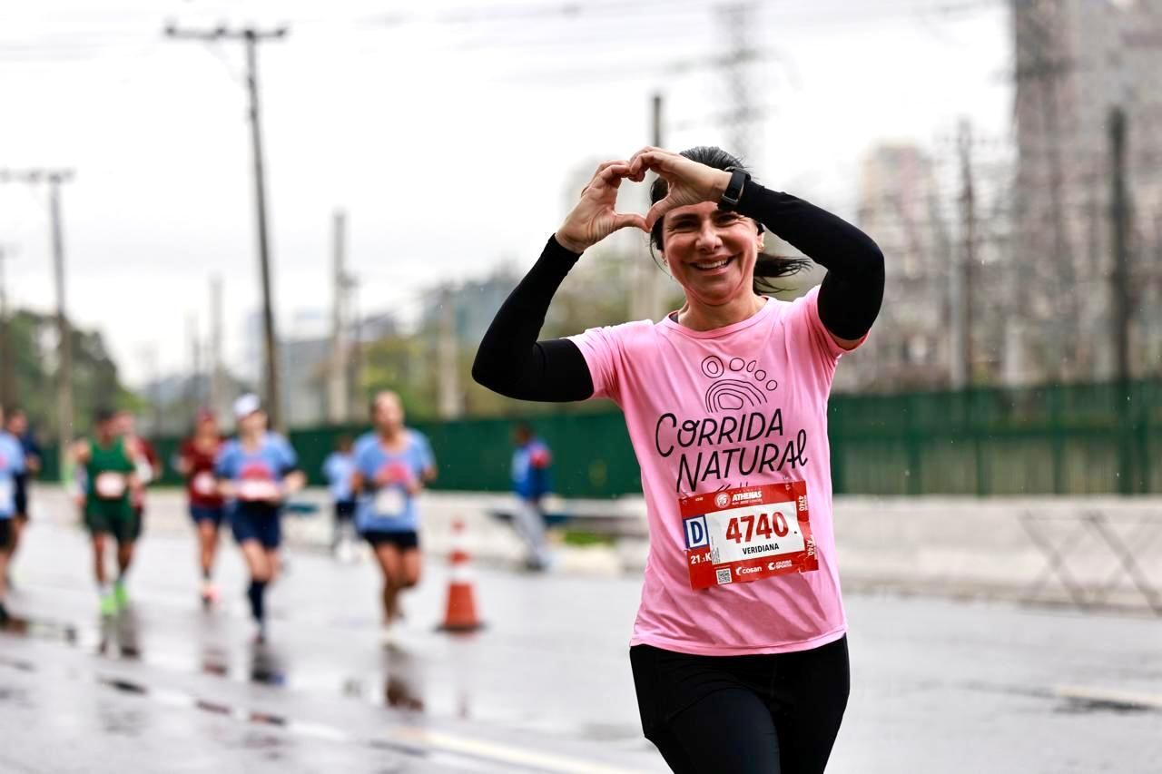 Aluna Veridiana fazendo coração com as mãos na meia maratona