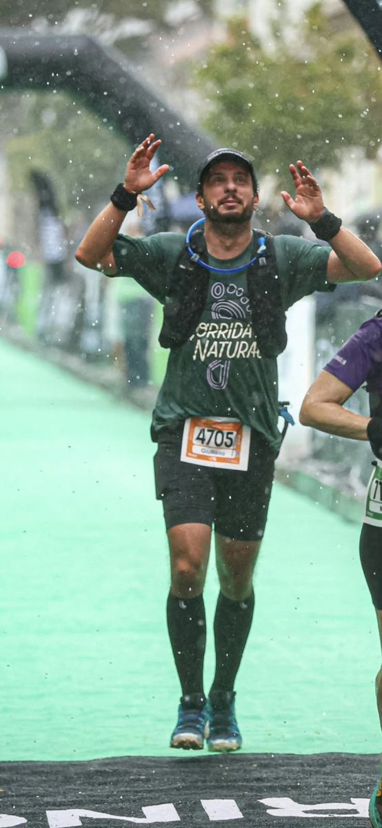 Aluno cruzando a linha de chegada na chuva