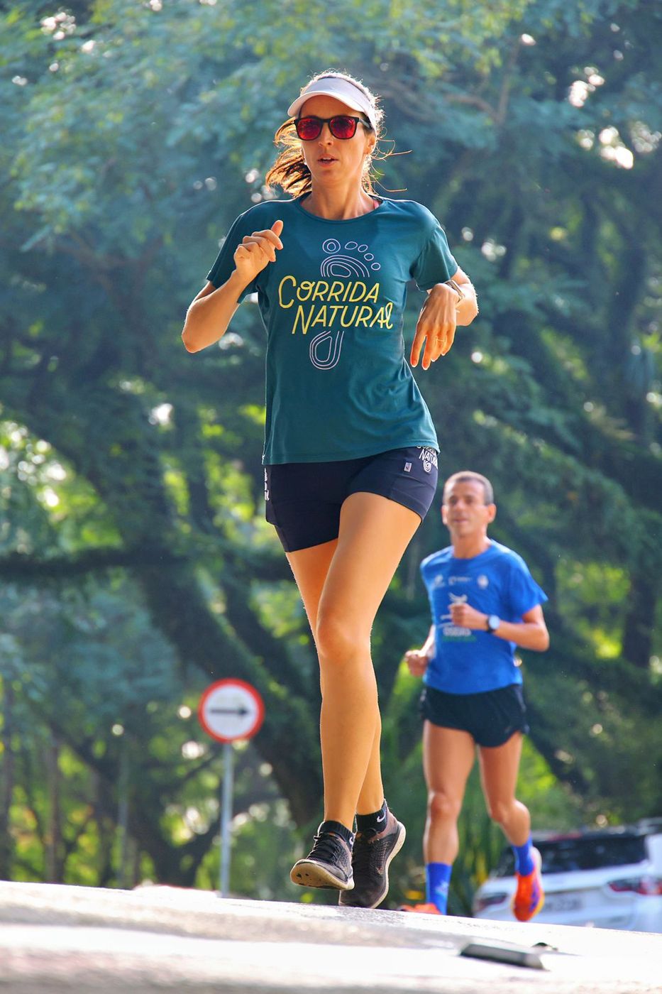 Valéria, treinadora da Corrida Natural, correndo em parque arborizado